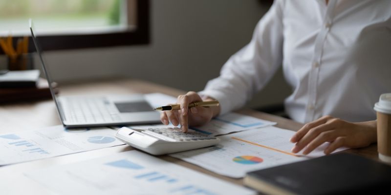 Mulher de negócios usando calculadora para fazer matemática, finanças no escritório, impostos, contabilidade, estatísticas e