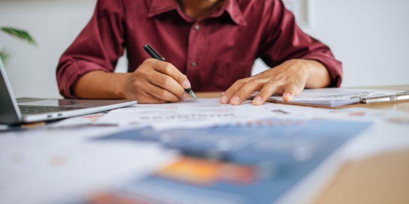 Um homem que trabalhando no escritório com papéis na mesa
